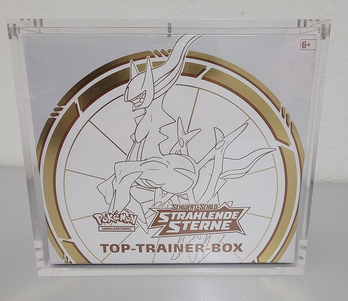 Transparentes Acrylcase mit 5 mm dicken Wänden und Magnetverschluss. Im Inneren sichtbar ist eine Pokémon Top Trainer Box. Die Box steht sicher und klar sichtbar zur Präsentation.